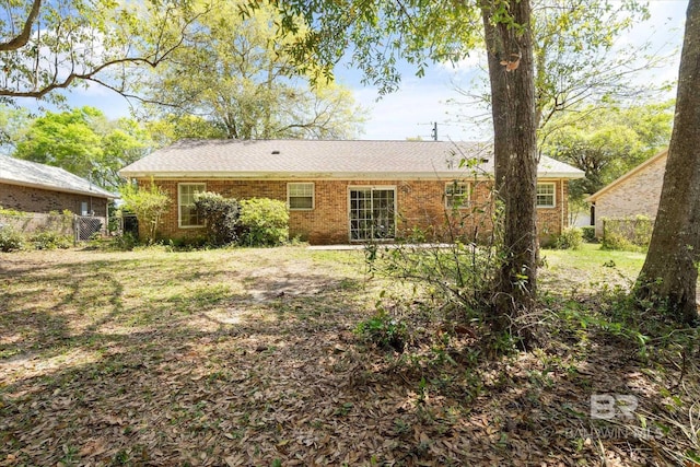 back of property featuring brick siding and fence