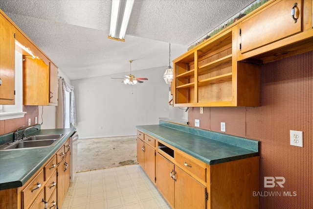 kitchen featuring a ceiling fan, a textured ceiling, white dishwasher, a sink, and light floors
