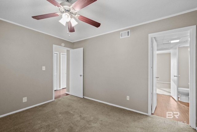 unfurnished bedroom featuring light colored carpet, ensuite bath, ceiling fan, and crown molding