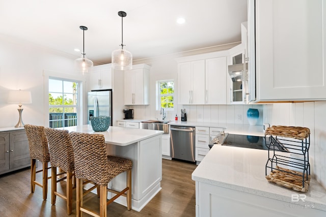 kitchen featuring a breakfast bar, a healthy amount of sunlight, backsplash, and appliances with stainless steel finishes