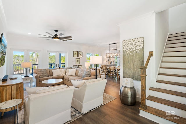 living room featuring dark hardwood / wood-style flooring, ceiling fan with notable chandelier, and ornamental molding