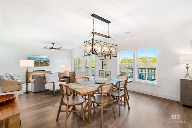 dining space with ceiling fan with notable chandelier and dark wood-type flooring