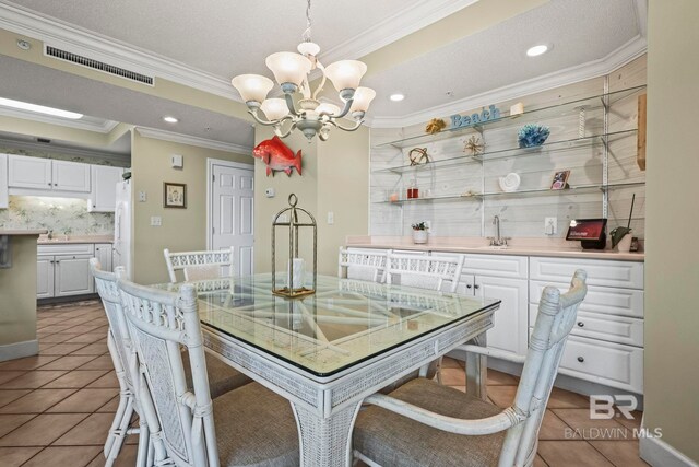 dining space featuring crown molding, light tile patterned flooring, and a chandelier