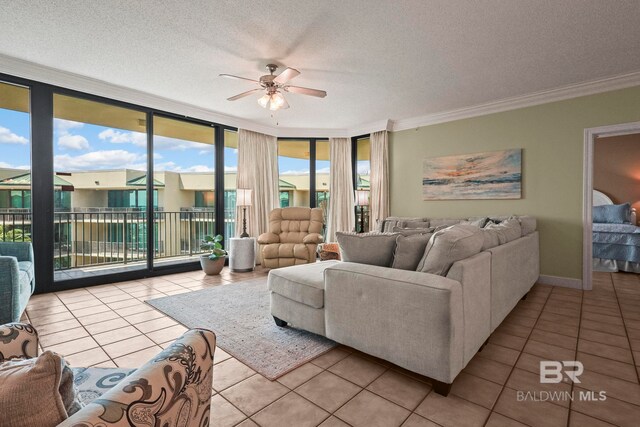 tiled living room with ceiling fan, ornamental molding, a textured ceiling, and expansive windows