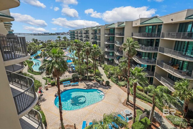 view of swimming pool featuring a water view and a patio area