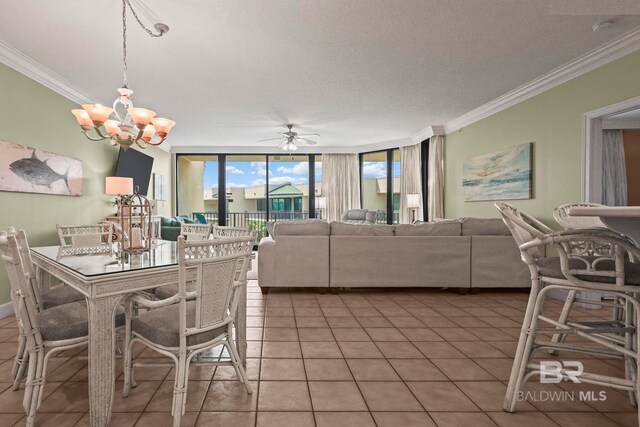 tiled dining area with ceiling fan with notable chandelier, a textured ceiling, a wall of windows, and ornamental molding