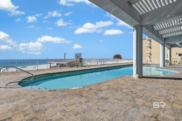 pool with a water view, a patio area, fence, and a pergola