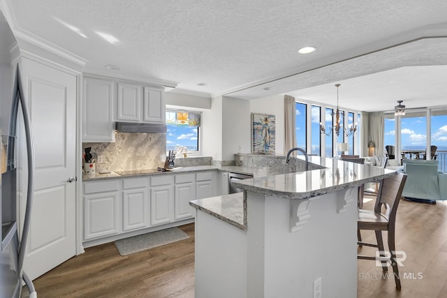 kitchen with light wood-type flooring, stainless steel appliances, a wealth of natural light, and a kitchen breakfast bar