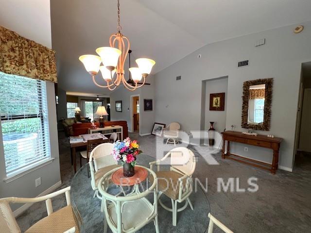 dining area featuring lofted ceiling, carpet flooring, and a chandelier