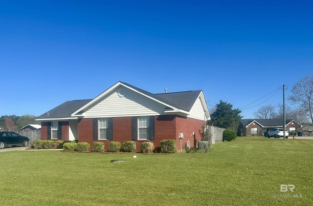 view of property exterior featuring a lawn, central AC unit, brick siding, and fence