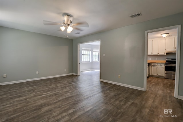 unfurnished living room featuring ceiling fan and dark hardwood / wood-style floors