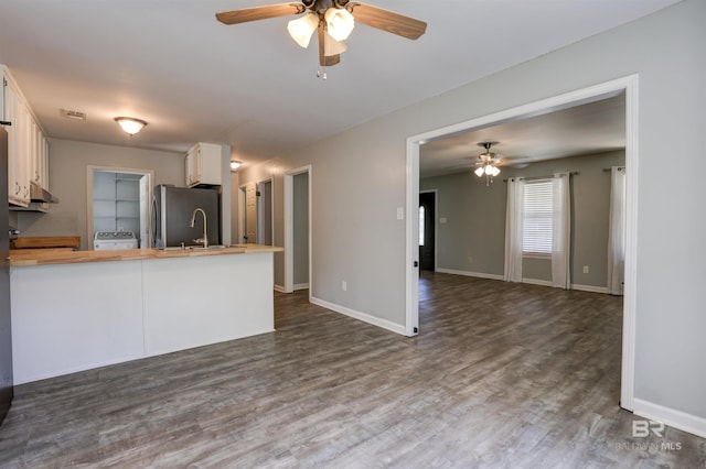 kitchen featuring ceiling fan, dark hardwood / wood-style floors, wood counters, white cabinetry, and kitchen peninsula