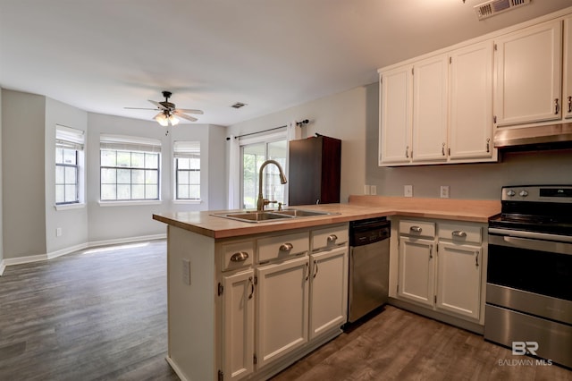 kitchen featuring kitchen peninsula, appliances with stainless steel finishes, and dark hardwood / wood-style flooring