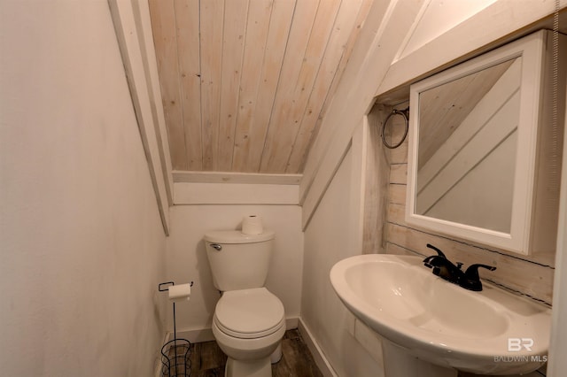 bathroom featuring hardwood / wood-style floors, vaulted ceiling, sink, wood ceiling, and toilet