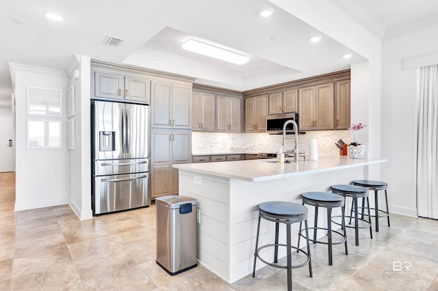 26688 Perdido Beach Blvd Unit 505, Orange Beach, AL 36561 - kitchen featuring visible vents, appliances with stainless steel finishes, a peninsula, crown molding, and a breakfast bar area