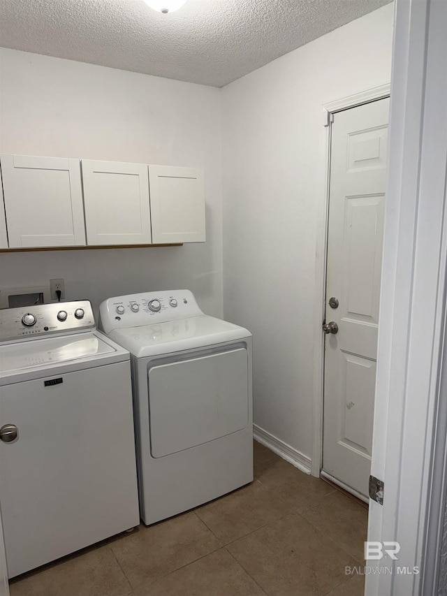 6950 Summerset Dr, Gulf Shores, AL 36542 - washroom featuring cabinet space, washer and dryer, a textured ceiling, and tile patterned flooring