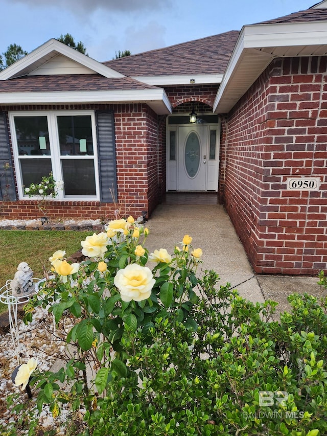 6950 Summerset Dr, Gulf Shores, AL 36542 - doorway to property featuring brick siding and roof with shingles