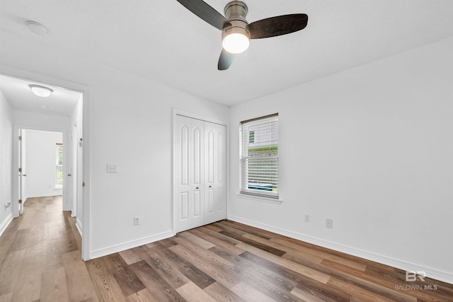 6950 Summerset Dr, Gulf Shores, AL 36542 - unfurnished bedroom featuring wood finished floors, baseboards, and multiple windows