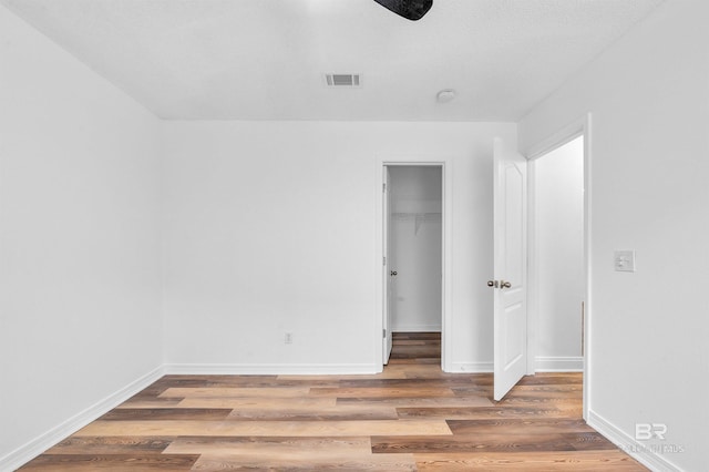 6950 Summerset Dr, Gulf Shores, AL 36542 - unfurnished bedroom featuring wood finished floors, a spacious closet, baseboards, and a closet