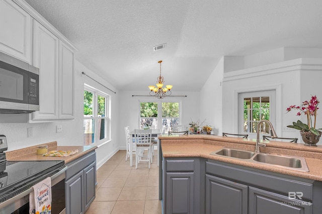 6950 Summerset Dr, Gulf Shores, AL 36542 - kitchen featuring stainless steel appliances, gray cabinetry, a sink, a chandelier, and white cabinetry