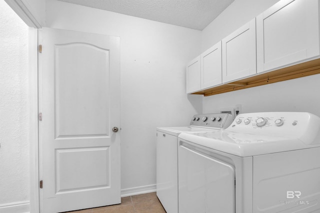 6950 Summerset Dr, Gulf Shores, AL 36542 - laundry room with cabinet space, washer and clothes dryer, baseboards, a textured ceiling, and light tile patterned flooring