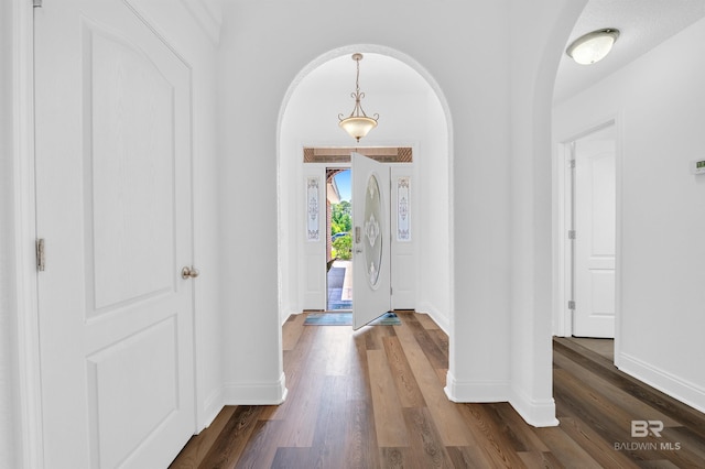 6950 Summerset Dr, Gulf Shores, AL 36542 - foyer entrance featuring arched walkways, dark wood-style floors, and baseboards