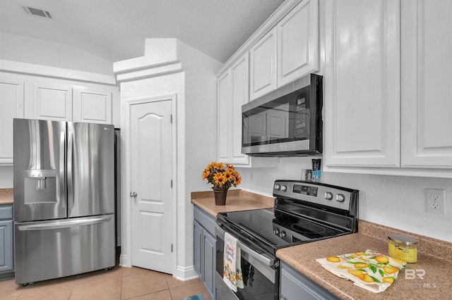 6950 Summerset Dr, Gulf Shores, AL 36542 - kitchen with stainless steel appliances, white cabinets, light tile patterned floors, a textured wall, and light countertops