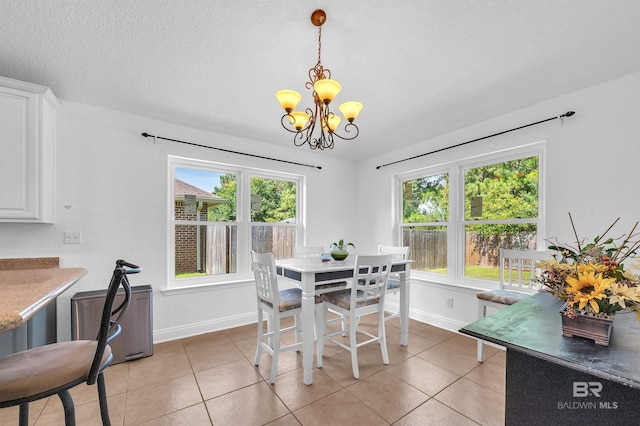 6950 Summerset Dr, Gulf Shores, AL 36542 - dining area featuring a chandelier, baseboards, light tile patterned floors, and a textured ceiling
