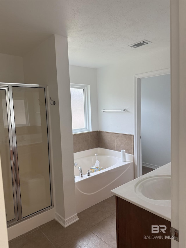 6950 Summerset Dr, Gulf Shores, AL 36542 - bathroom with a shower stall, a garden tub, tile patterned flooring, vanity, and a textured ceiling