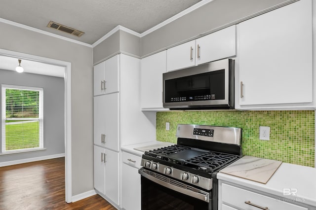 kitchen featuring appliances with stainless steel finishes, visible vents, tasteful backsplash, and light countertops