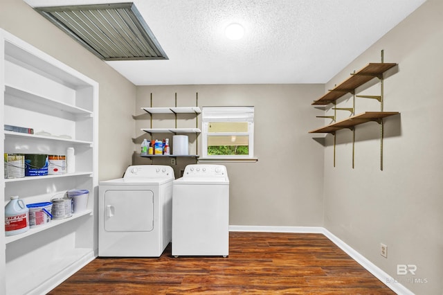 washroom featuring washer and dryer, wood finished floors, laundry area, and a textured ceiling