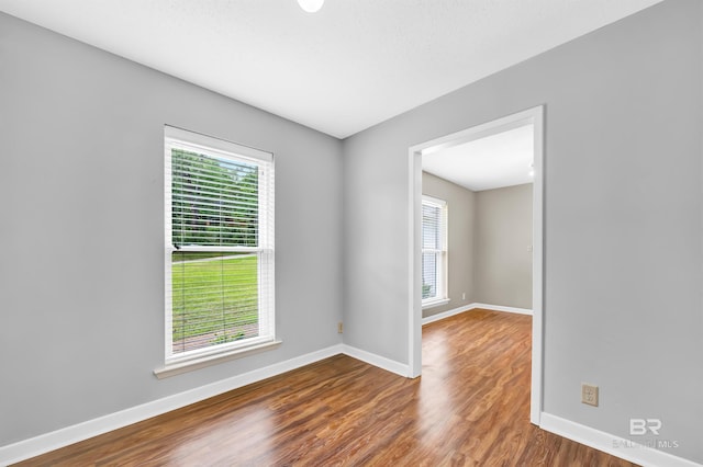 empty room featuring wood finished floors and baseboards