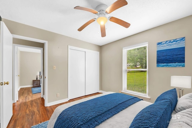 bedroom featuring a closet, ceiling fan, wood finished floors, and baseboards