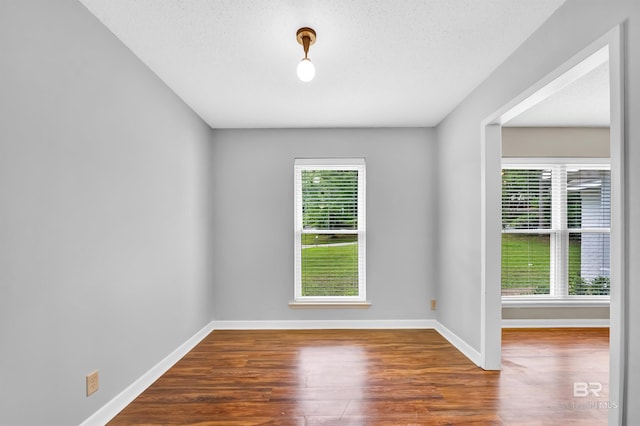 empty room featuring wood finished floors and baseboards
