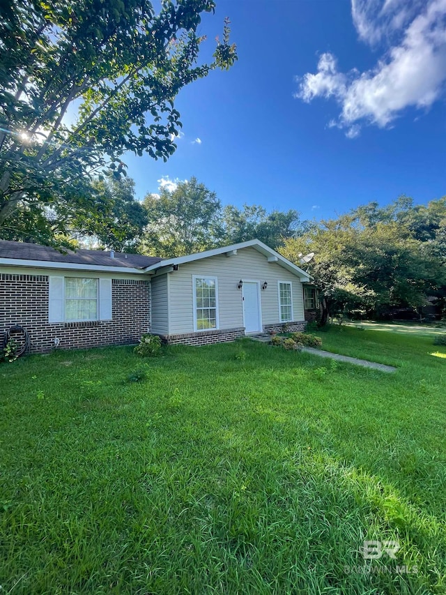 rear view of property featuring a lawn