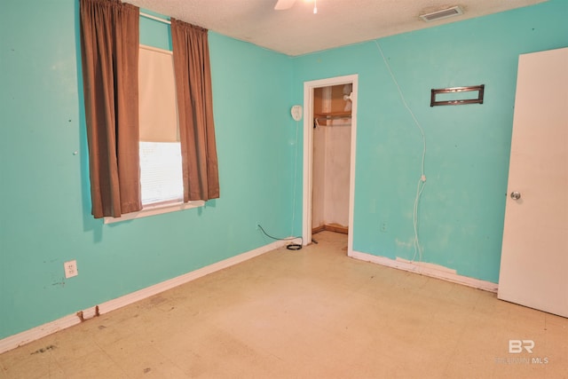 spare room with ceiling fan and a textured ceiling