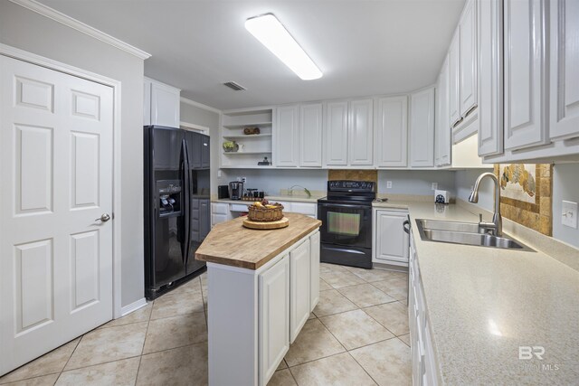 kitchen featuring black appliances, white cabinetry, sink, a kitchen island, and butcher block countertops