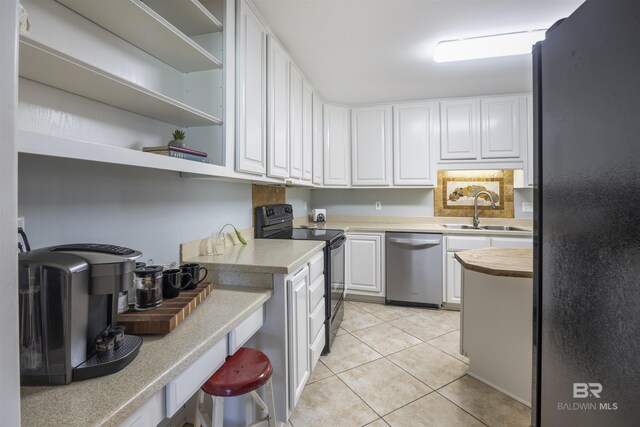 kitchen featuring white cabinets, black refrigerator, sink, range with electric cooktop, and stainless steel dishwasher