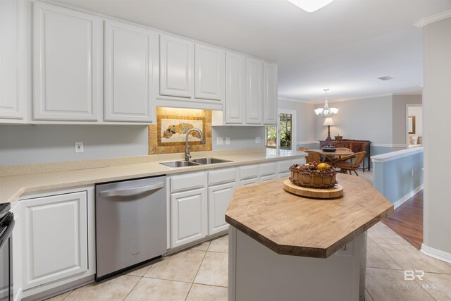 kitchen featuring white cabinets, appliances with stainless steel finishes, a kitchen island, sink, and light tile patterned floors