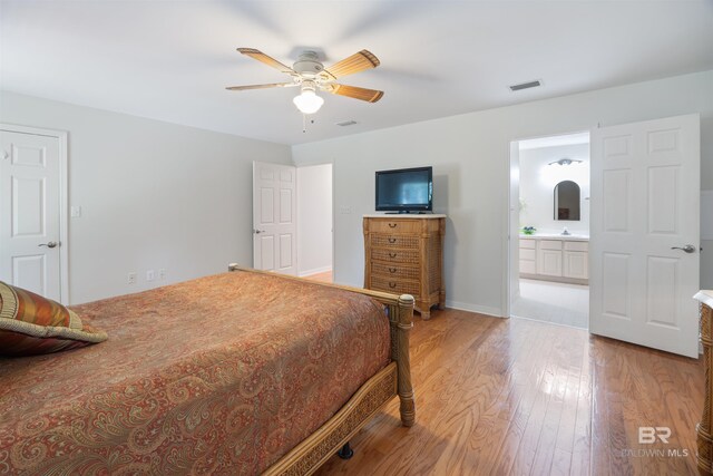 bedroom with ceiling fan, light hardwood / wood-style flooring, and ensuite bath