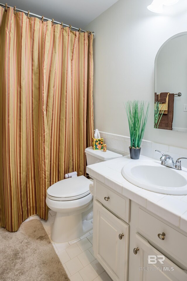 bathroom featuring vanity, toilet, and tile patterned floors