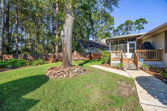 view of yard with a wooden deck and a sunroom