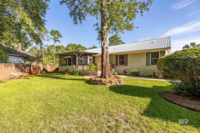 exterior space featuring a yard and a sunroom