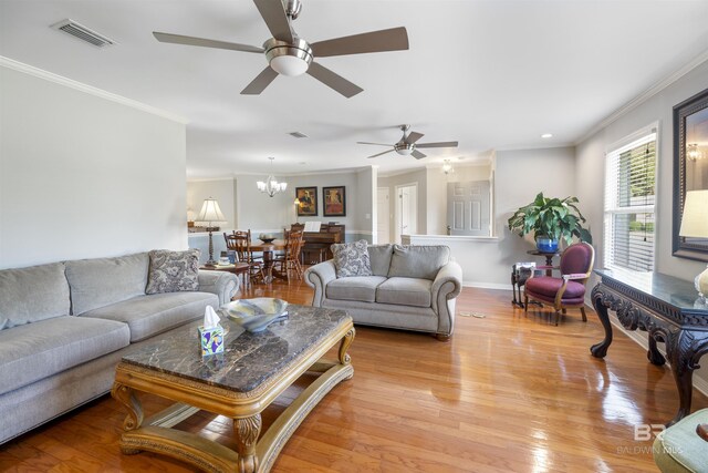 living room featuring crown molding, light hardwood / wood-style floors, and an inviting chandelier