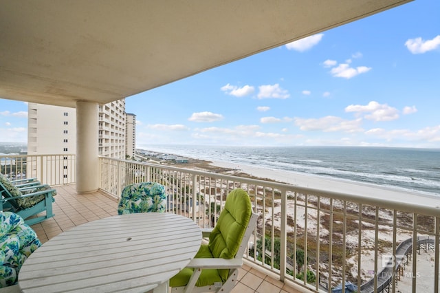 balcony featuring a view of the beach and a water view