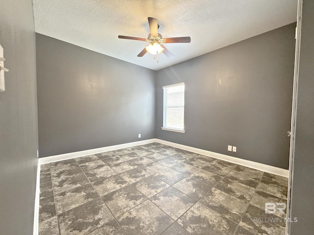 spare room featuring baseboards, a ceiling fan, and a textured ceiling
