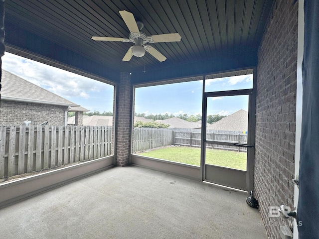 unfurnished sunroom featuring ceiling fan