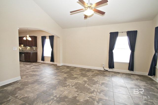 unfurnished room featuring arched walkways, baseboards, lofted ceiling, and ceiling fan with notable chandelier