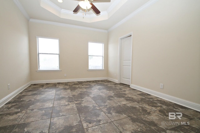 spare room featuring crown molding, a tray ceiling, ceiling fan, and a wealth of natural light