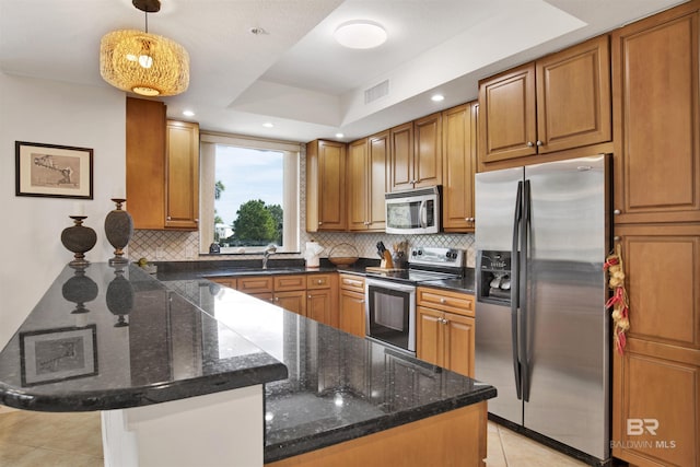 kitchen with stainless steel appliances, a peninsula, visible vents, and brown cabinets